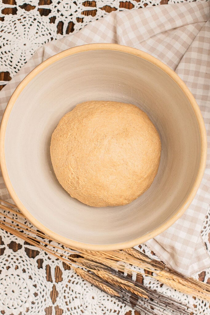 Cinnamon roll dough made with freshly milled flour resting in a bowl before the first rise