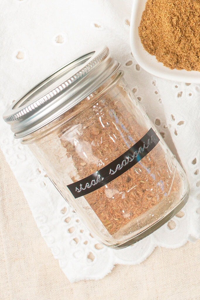 Homemade steak seasoning stored in a glass mason jar with a black label reading steak seasoning, ready for pantry storage