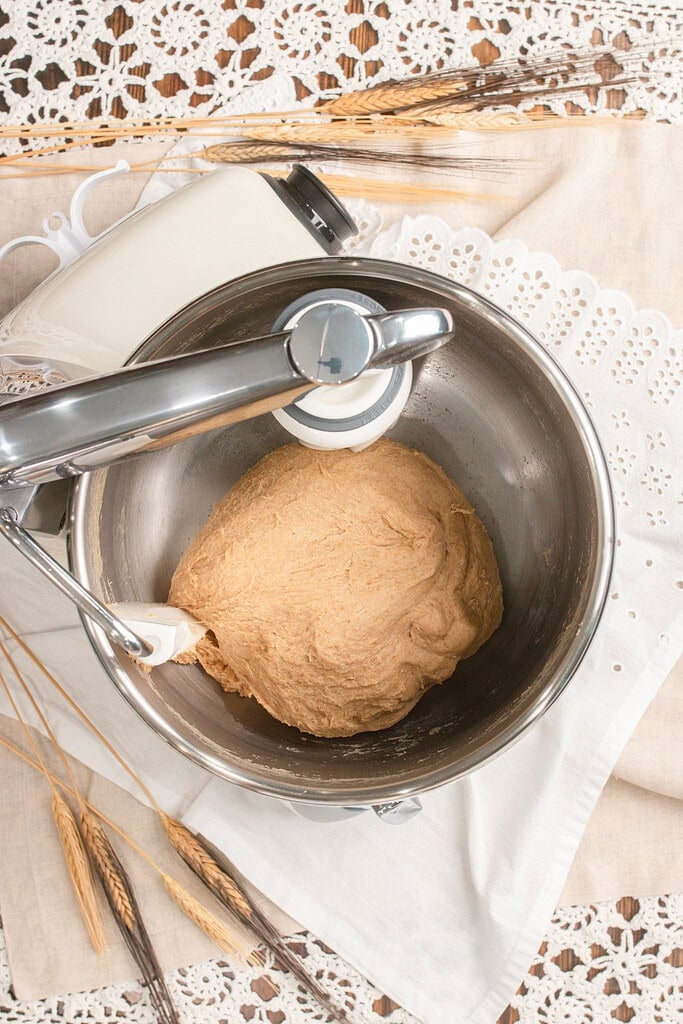A smooth kneaded ball of Fresh Milled Flour Sandwich Bread dough in a stand mixer bowl, attached to the dough hook
