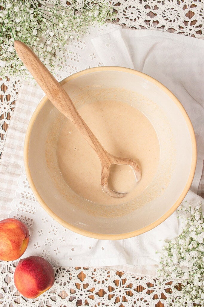 Smooth sourdough cobbler batter made with fresh milled flour mixed and ready to pour over fresh peaches.