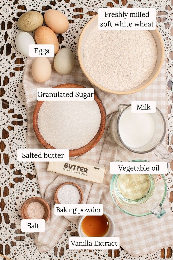 Yellow Cake Made with Freshly Milled Flour ingredients including eggs, sugar, butter, and milled flour laid out on a table